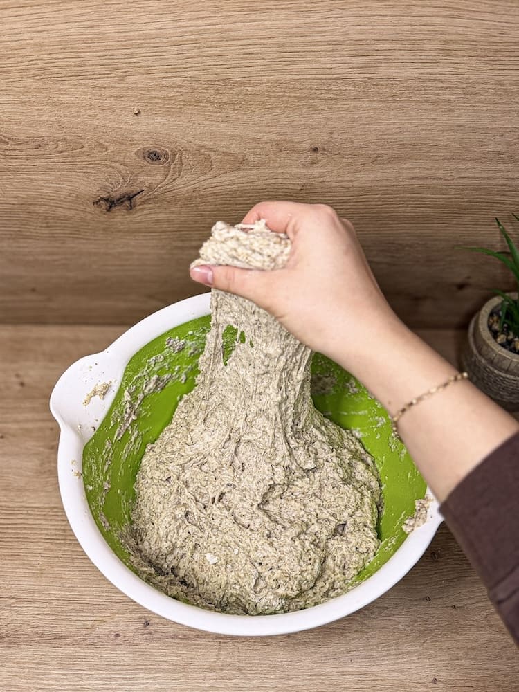 Sauerteig wird beim Dehnen und Falten in der Schüssel bearbeitet