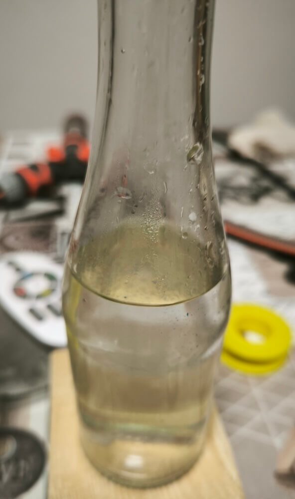 Erstes Destillat der Schafgarbe sammelt sich in der Vorlageflasche