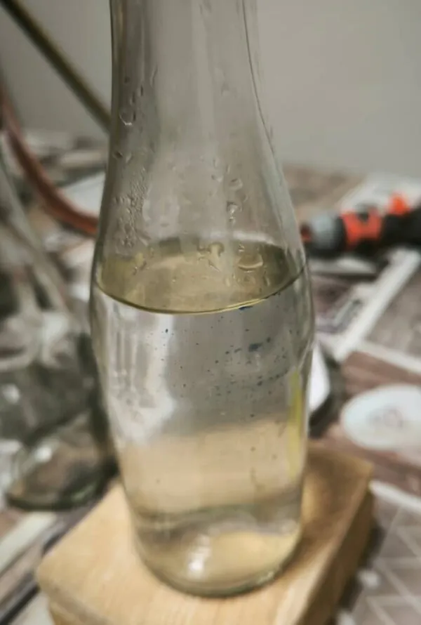 Schafgarbenhydrolat läuft während der Destillation in die Glasflasche