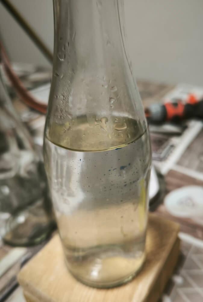 Schafgarbenhydrolat läuft während der Destillation in die Glasflasche