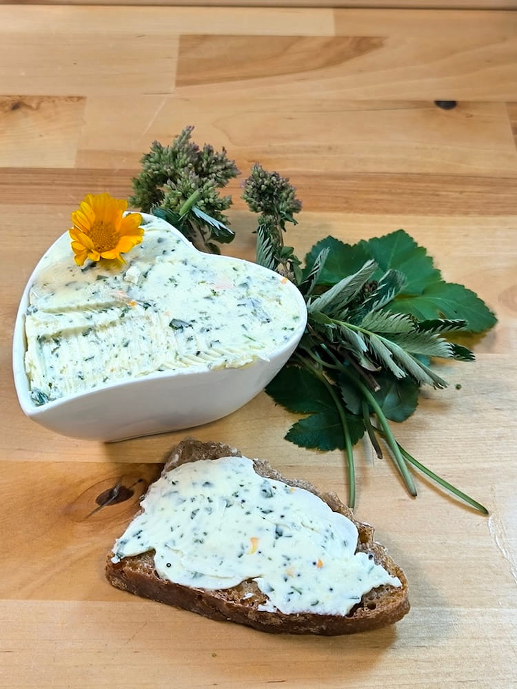 Wildkräuterbutter auf einer Scheibe frischem Brot