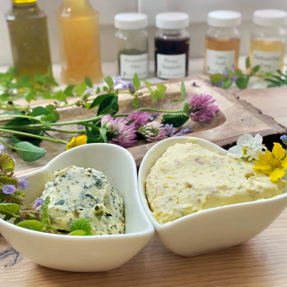 Angeschnittene Rolle Wildkräuterbutter mit grünen Kräutern und Blüten